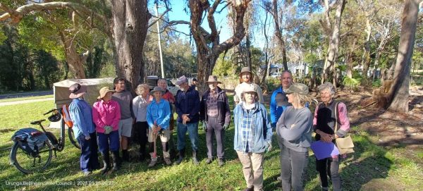 a group of 14 people prepare to plant native species in Urunga